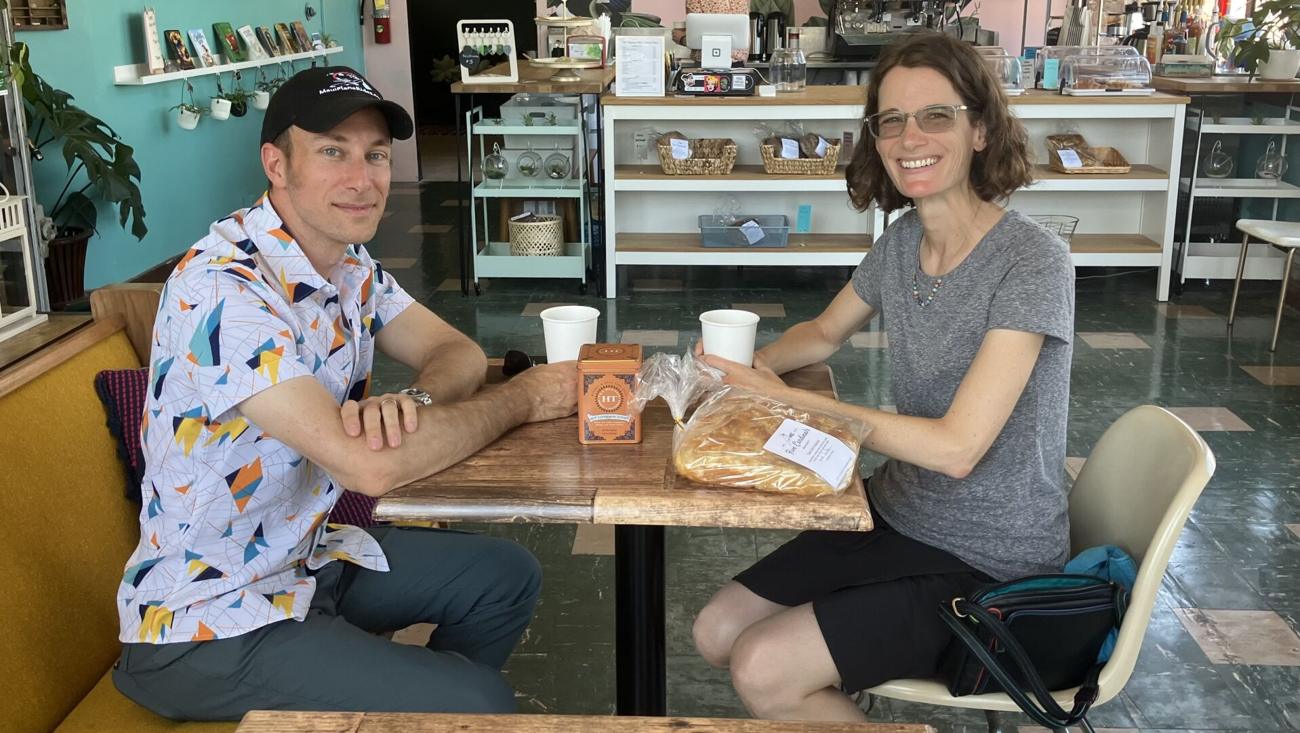 Two people talking over coffee at a wooden table in The Magpies' Nest