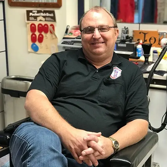 John Stadler smiling in his barber chair
